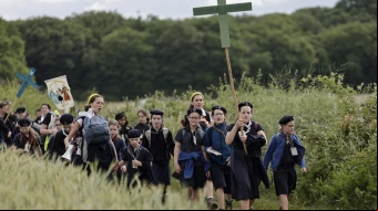 Jóvenes sostienen cruces mientras llegan para la Misa durante la tradicional peregrinación de Pentecostés de París a Chartres, en Sonchamp, cerca de París (Francia), el 8 de junio de 2025.