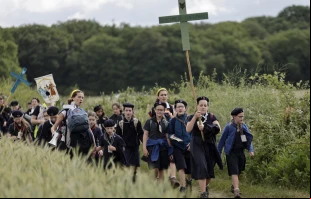 Jóvenes sostienen cruces mientras llegan para la Misa durante la tradicional peregrinación de Pentecostés de París a Chartres, en Sonchamp, cerca de París (Francia), el 8 de junio de 2025. Crédito: STEPHANE DE SAKUTIN/AFP vía Getty Images.