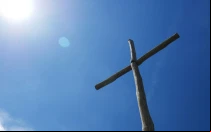 Una cruz se eleva hacia el cielo azul. Imagen referencial.